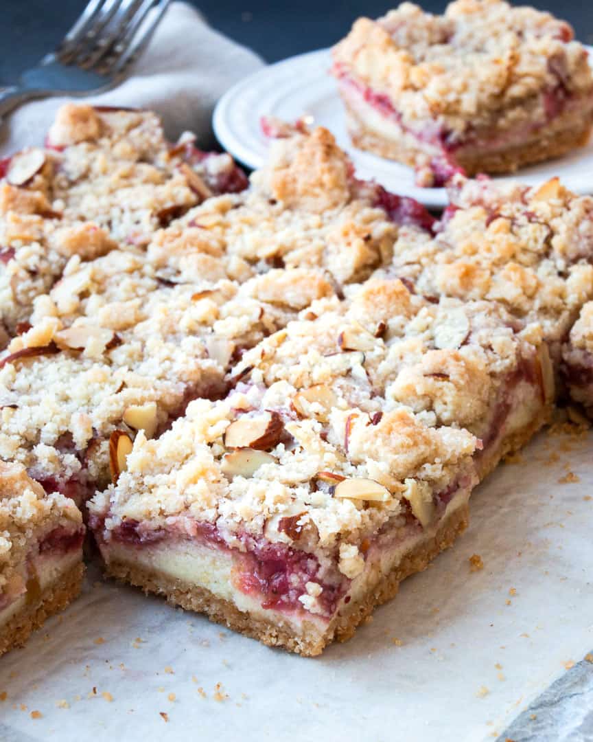 A plate of cookie bars filled with cheesecake and strawberry rhubarb.